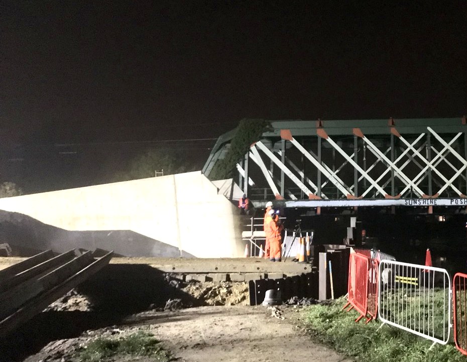 Concrete abutment on a live bridge with the surveyor on instrument