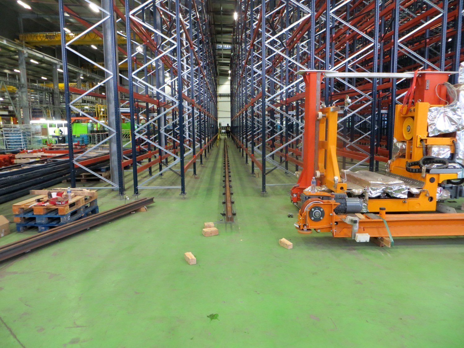Warehouse racking and rail being set out on a factory floor